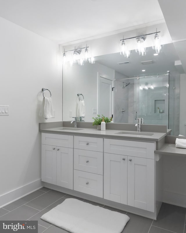 full bathroom featuring a stall shower, tile patterned floors, a sink, and double vanity