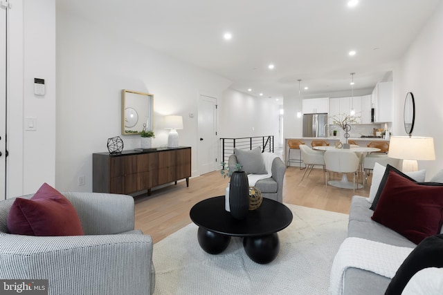 living area with light wood-type flooring and recessed lighting