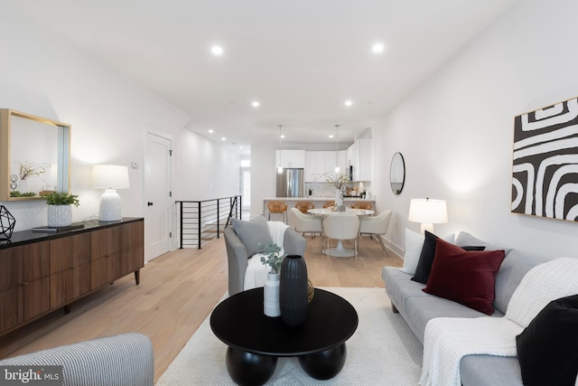 living room with baseboards, light wood-style flooring, and recessed lighting