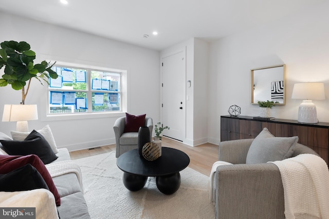 living room featuring light wood-style floors, recessed lighting, visible vents, and baseboards