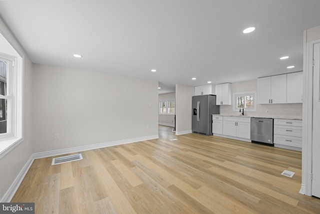 kitchen with a wealth of natural light, appliances with stainless steel finishes, a sink, and visible vents