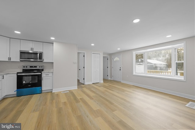 kitchen featuring appliances with stainless steel finishes, recessed lighting, white cabinets, and light wood-style floors