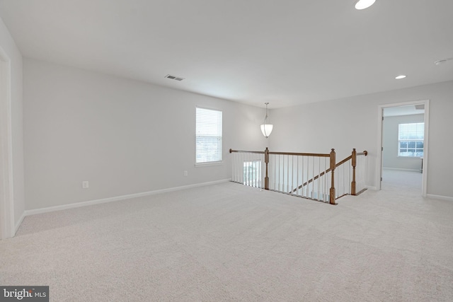 empty room with visible vents, recessed lighting, baseboards, and carpet