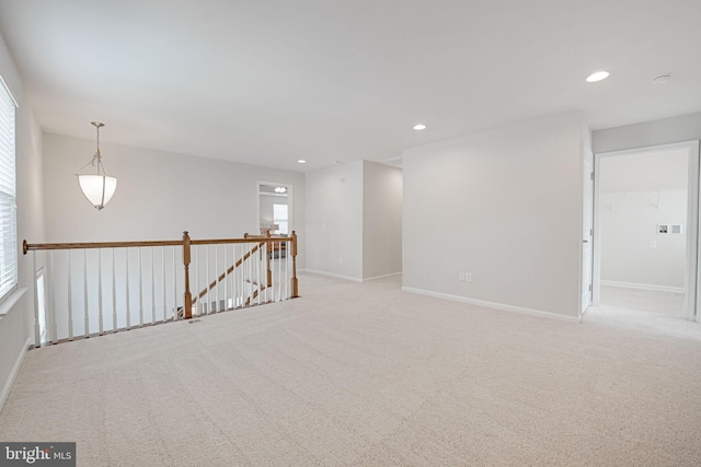 empty room featuring recessed lighting, baseboards, and light colored carpet