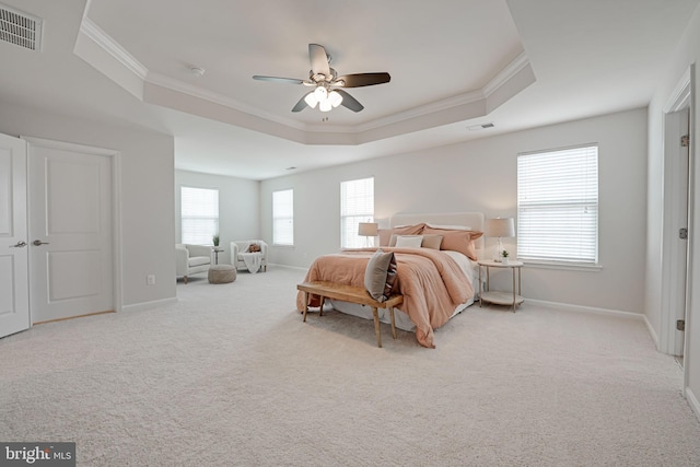 carpeted bedroom featuring a raised ceiling, baseboards, and visible vents