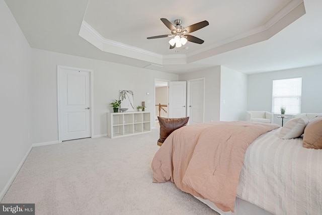 bedroom with baseboards, a raised ceiling, light colored carpet, and ornamental molding