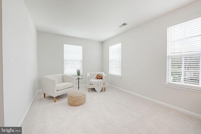 living area featuring visible vents, carpet floors, and baseboards