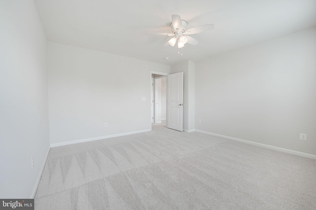 spare room featuring ceiling fan, baseboards, and carpet