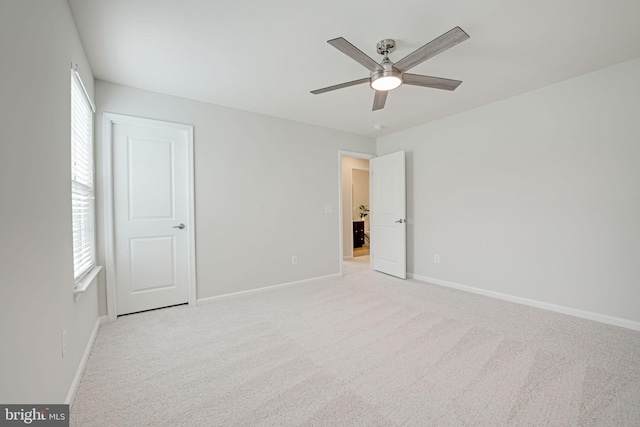 unfurnished bedroom featuring baseboards, light carpet, and a ceiling fan