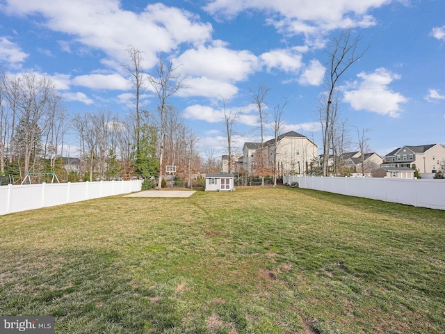 view of yard featuring an outbuilding, a storage unit, and a fenced backyard