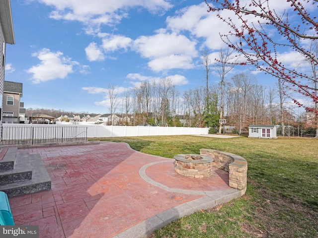 view of patio featuring an outbuilding, fence, and an outdoor fire pit