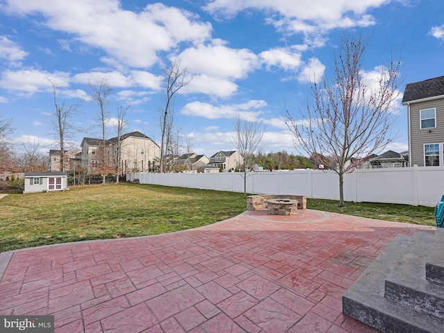 view of patio / terrace with an outbuilding, fence private yard, and an outdoor fire pit