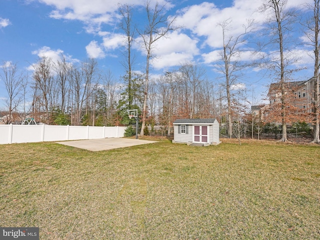 view of yard featuring a storage unit, an outbuilding, and a fenced backyard