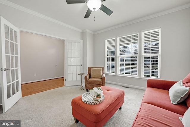 sitting room with french doors, ornamental molding, and carpet flooring