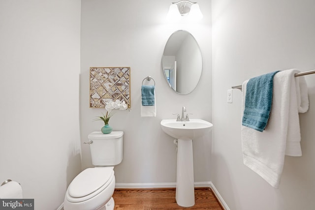 bathroom featuring toilet, baseboards, and wood finished floors