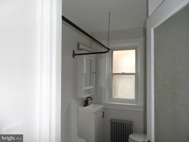 bathroom featuring radiator, toilet, and a sink