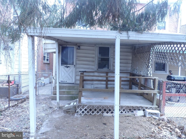 doorway to property with log veneer siding and fence