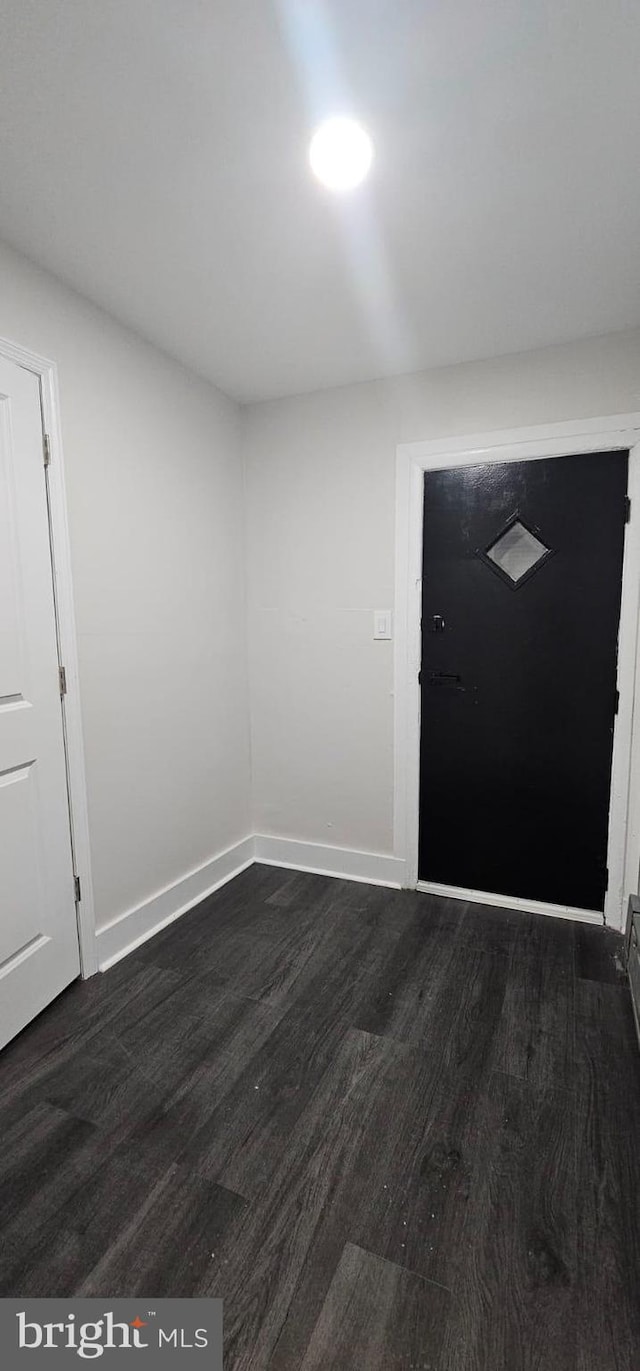 foyer entrance featuring dark wood finished floors and baseboards