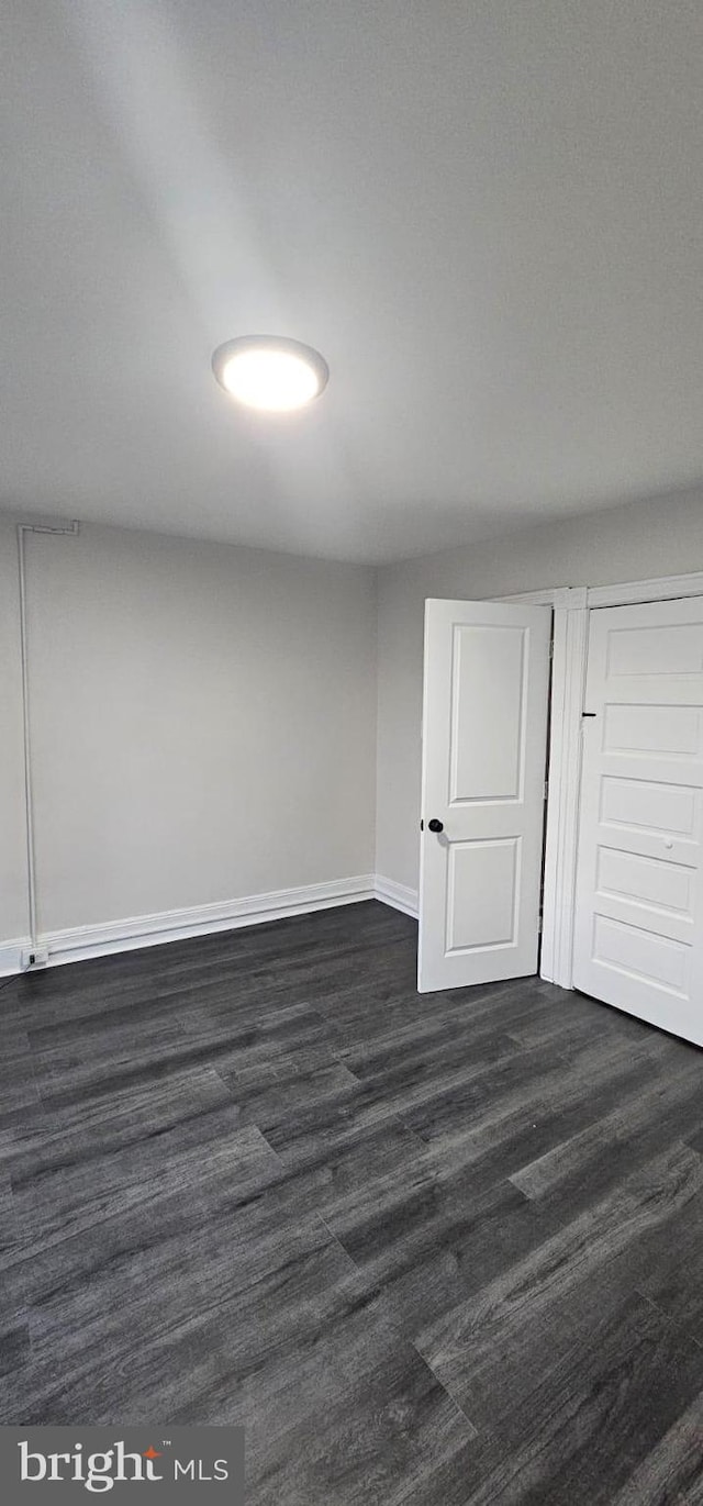 below grade area featuring dark wood-style flooring and baseboards