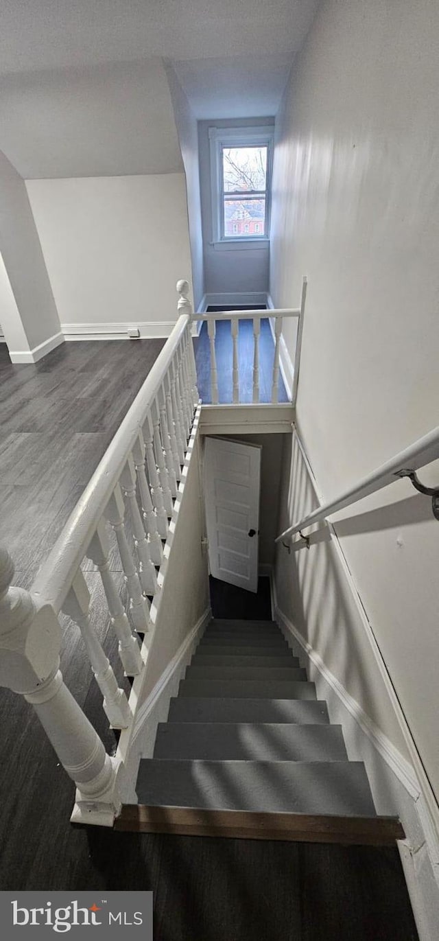 stairs featuring wood finished floors and baseboards