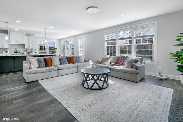 living area with baseboards, dark wood-type flooring, and recessed lighting