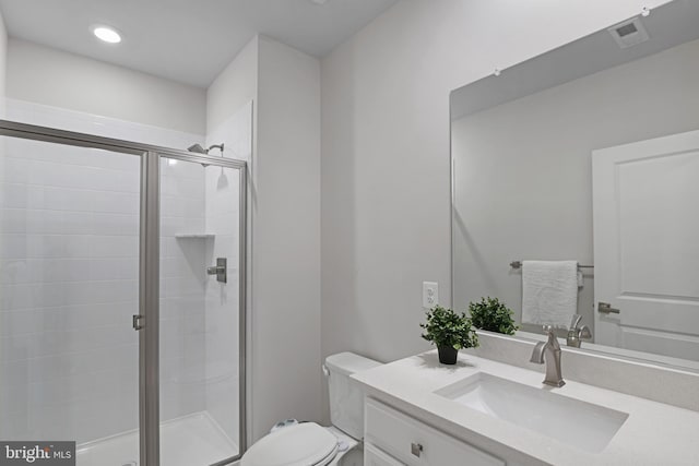 bathroom with visible vents, vanity, a shower stall, and toilet