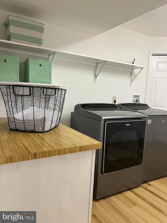 laundry room featuring light wood-style floors, washer and dryer, and laundry area