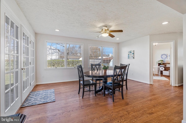 dining area with a textured ceiling, recessed lighting, wood finished floors, a ceiling fan, and baseboards