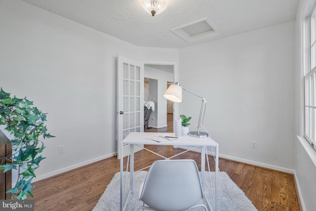 office space featuring plenty of natural light, wood finished floors, and attic access