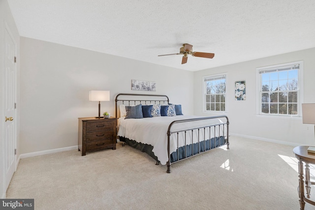 carpeted bedroom with a ceiling fan, baseboards, and a textured ceiling