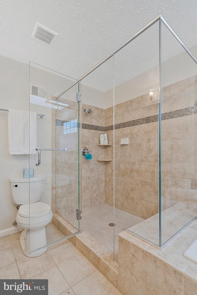 full bath featuring visible vents, toilet, a stall shower, a textured ceiling, and tile patterned floors