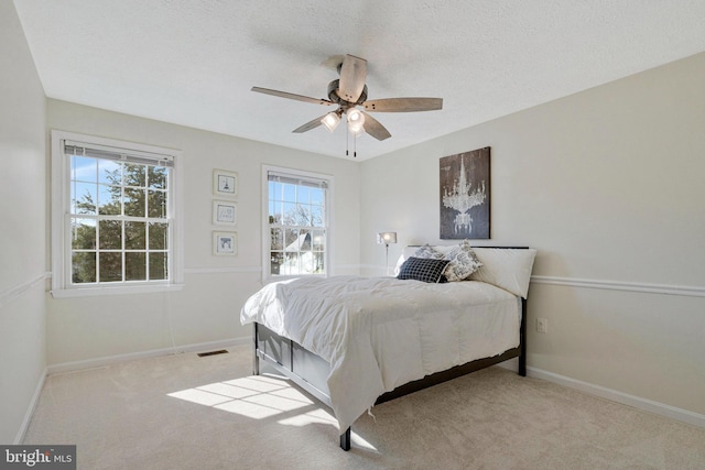 bedroom with carpet floors, baseboards, visible vents, and a textured ceiling