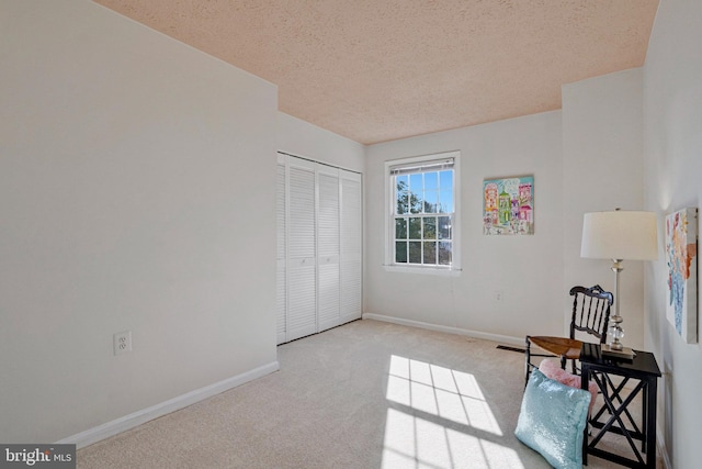 unfurnished room with a textured ceiling, baseboards, and carpet flooring