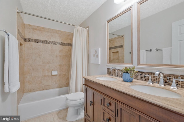 bathroom featuring a sink, a textured ceiling, toilet, and tile patterned floors