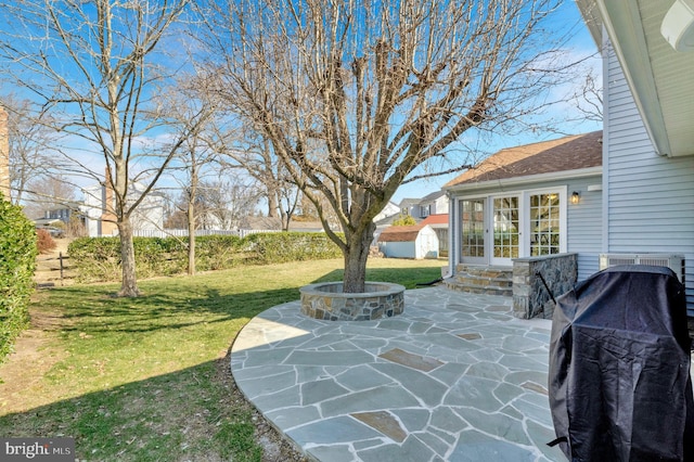 view of patio featuring entry steps, grilling area, and an outbuilding