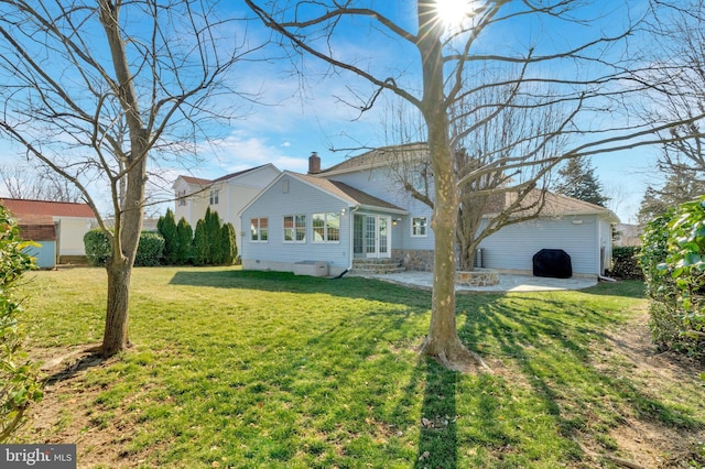 view of front facade featuring entry steps, a front yard, crawl space, a chimney, and a patio area