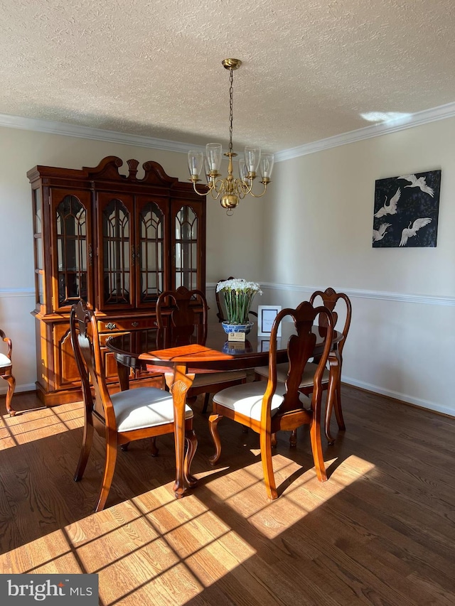 dining room featuring crown molding, a textured ceiling, an inviting chandelier, and wood finished floors