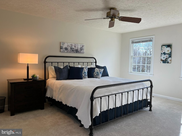 carpeted bedroom with ceiling fan, a textured ceiling, and baseboards