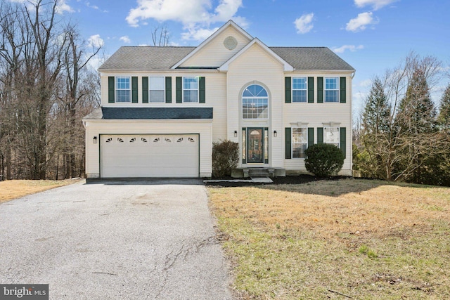 view of front facade with a garage, a front yard, and driveway