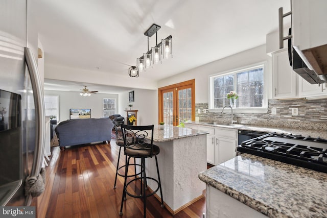 kitchen featuring white cabinets, dark wood-style floors, decorative backsplash, and freestanding refrigerator