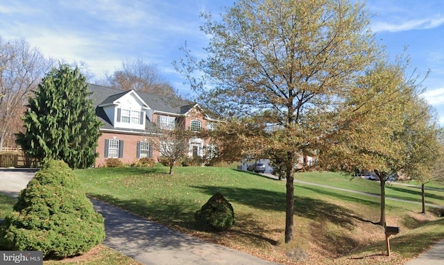 view of front of property featuring a front yard and brick siding