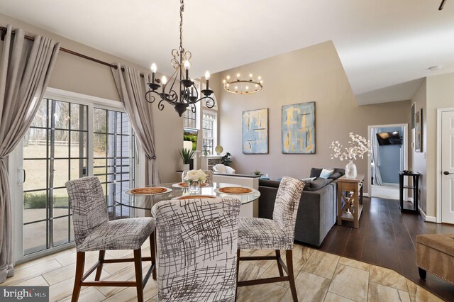 dining space with a chandelier, plenty of natural light, and wood finished floors