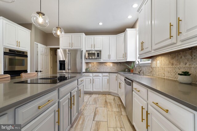 kitchen featuring white cabinets, stainless steel appliances, and a sink