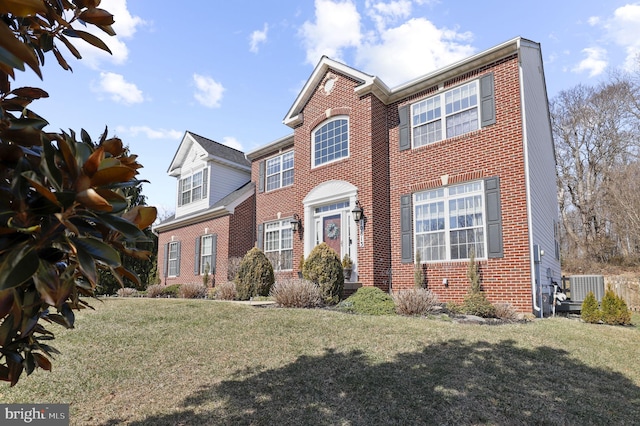 view of front of property featuring brick siding, central air condition unit, and a front lawn