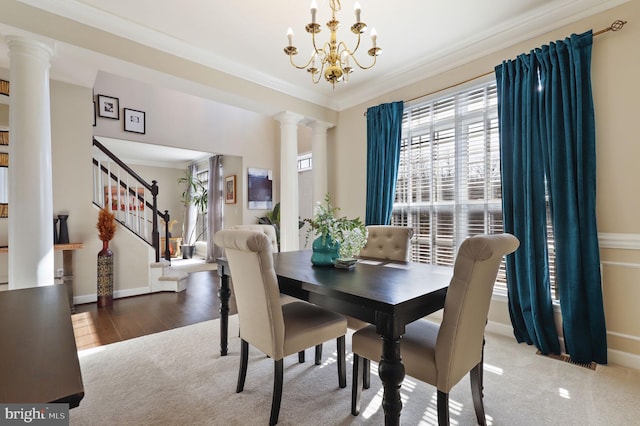 dining area with decorative columns, carpet flooring, crown molding, and stairway