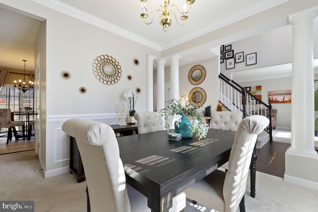 dining area with an inviting chandelier, crown molding, light colored carpet, and ornate columns