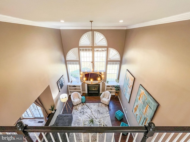 living room featuring stairway, baseboards, a notable chandelier, and crown molding