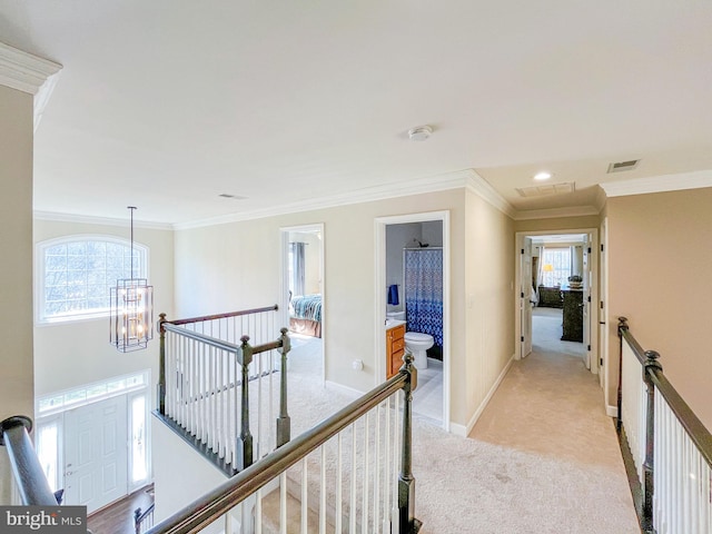 hallway featuring visible vents, ornamental molding, an upstairs landing, light carpet, and a notable chandelier