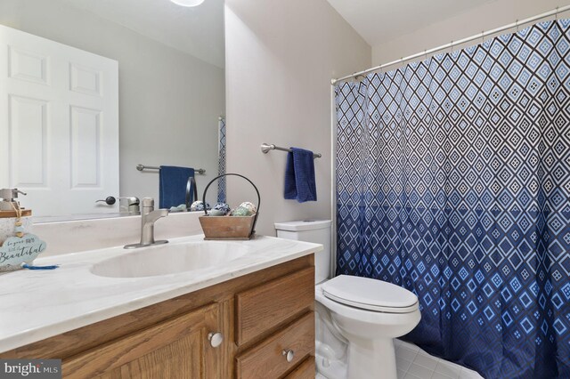 full bath with tile patterned floors, a shower with shower curtain, toilet, and vanity