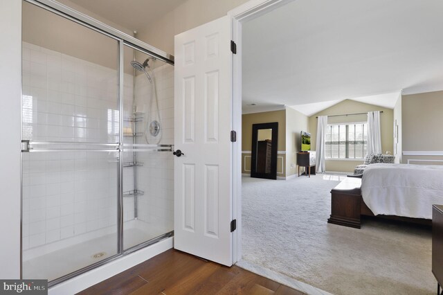 ensuite bathroom with wood finished floors, ensuite bath, a stall shower, and vaulted ceiling